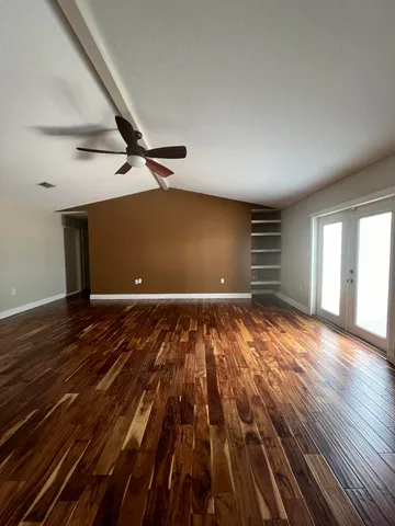 a view of empty room with wooden floor