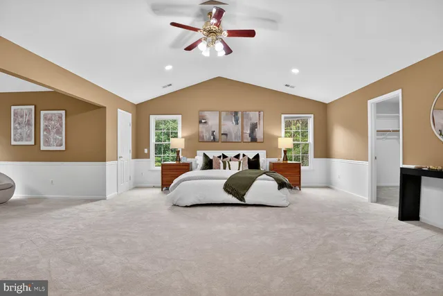 a spacious bedroom with a large bed and a chandelier