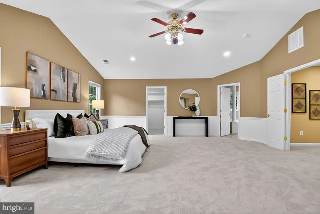 a spacious bedroom with a bed and a chandelier