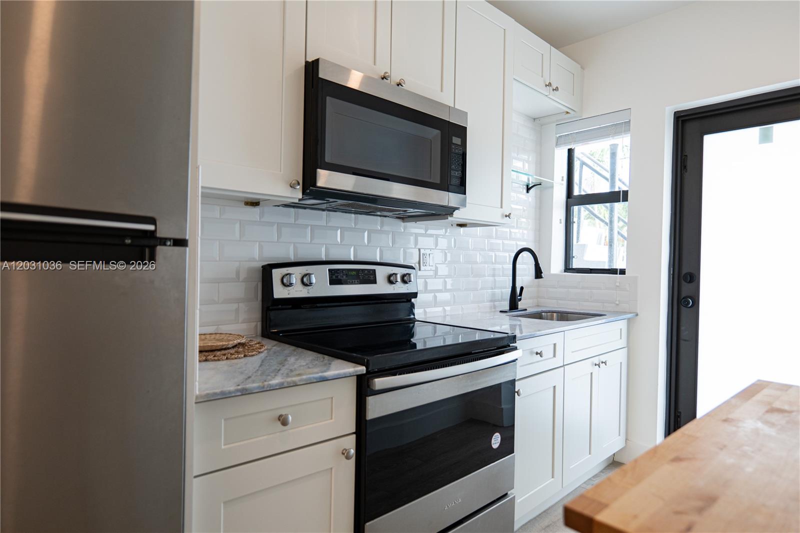 1721 Southwest 13th Street, Unit 4 Miami, FL 33145 - Photo 5 of 24 a kitchen with stainless steel appliances granite countertop a stove microwave and sink