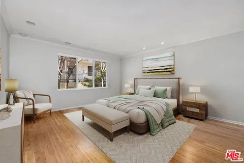 a spacious bedroom with a bed a couch and a window