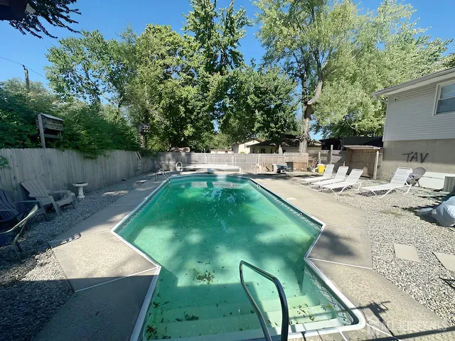 a swimming pool with outdoor seating and yard