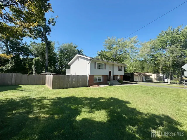 a house view with a play ground and a large tree