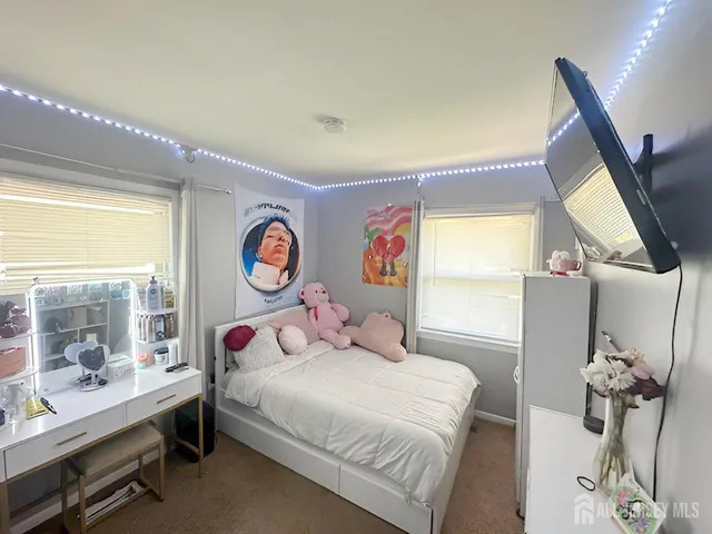 a bedroom with a bed and a dresser next to a window