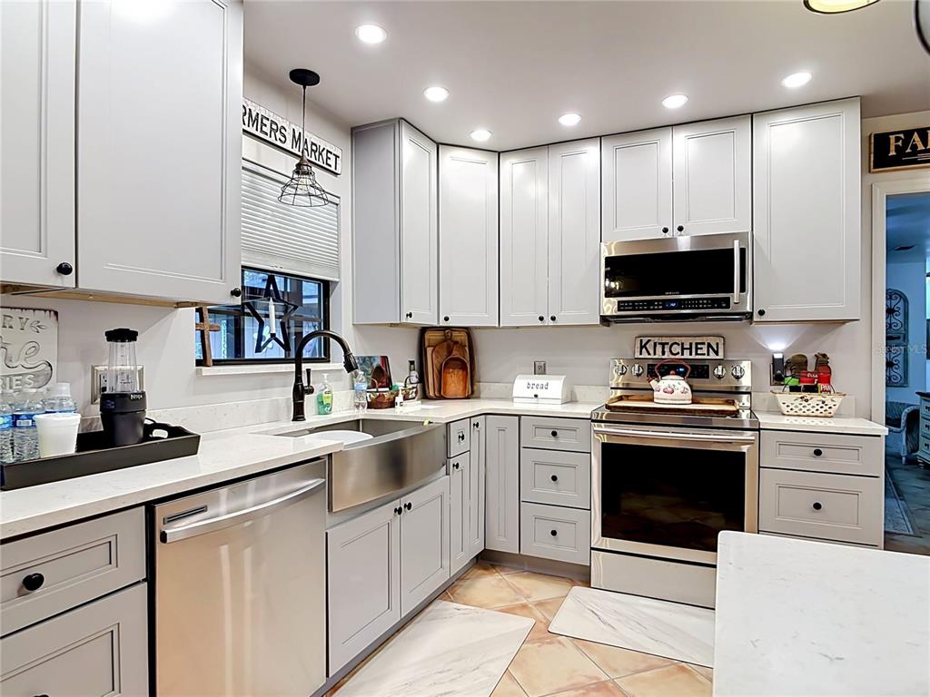 1395 Maytown Road Osteen, FL 32764 - Photo 21 of 65 a kitchen with stainless steel appliances granite countertop a sink and dishwasher a stove top oven with white cabinets