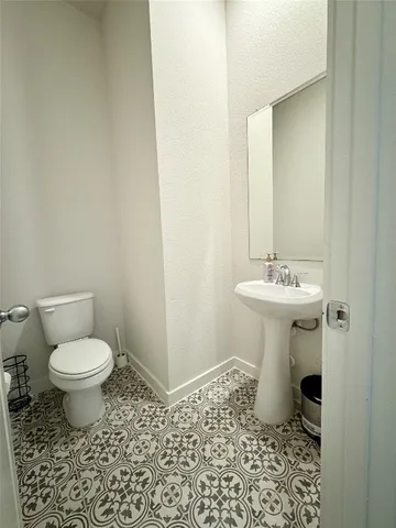 a bathroom with a sink toilet and a mirror