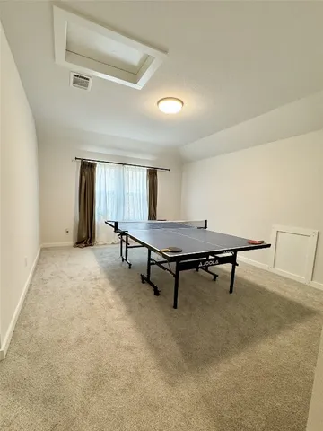 a living room with furniture pool table and windows