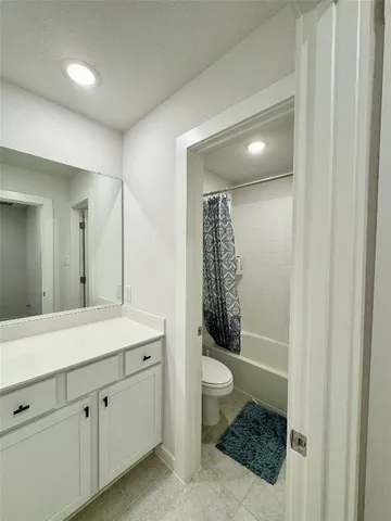 a spacious bathroom with a shower a sink and a mirror
