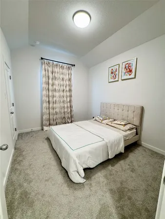 a spacious bedroom with a bed and a window