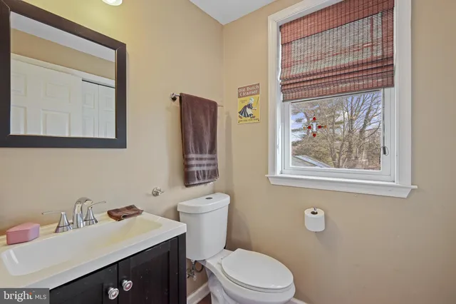 a bathroom with a sink vanity mirror and toilet