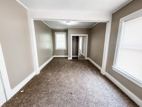 an empty room with windows and closet
