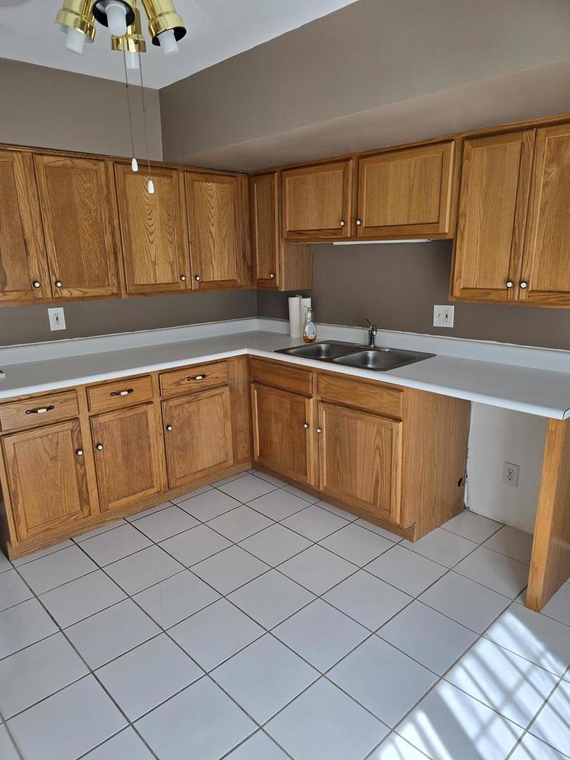 19360 Wolf Road, Unit 1 Mokena, IL 60448 - Photo 6 of 11 a kitchen with a sink cabinets and window
