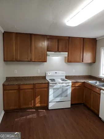 a kitchen with granite countertop wood cabinets and white appliances