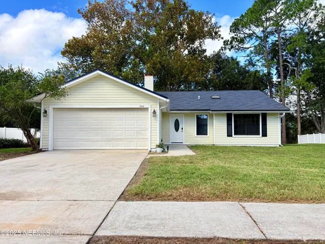 a front view of a house with a garden and trees