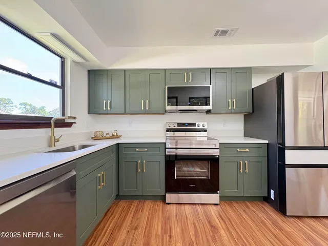 a kitchen with stainless steel appliances a stove sink and refrigerator