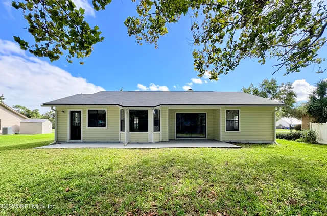 a front view of house with yard and trees around