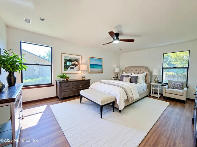 a spacious bedroom with a bed a couch and a potted plant