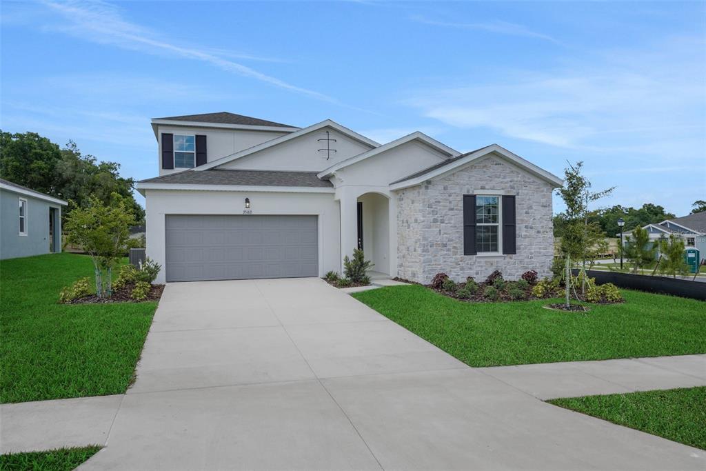 35163 Tuscan Hill Road Dade City, FL 33525 - Photo 2 of 45 a front view of a house with a yard and garage