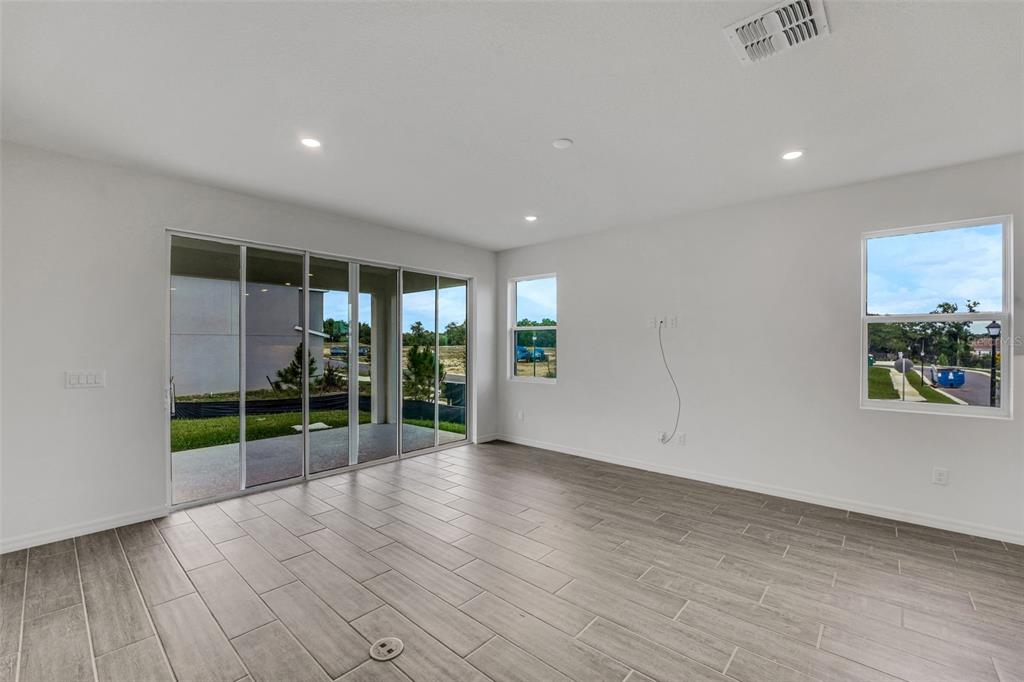 35163 Tuscan Hill Road Dade City, FL 33525 - Photo 23 of 45 an empty room with floor to ceiling window and wooden floor