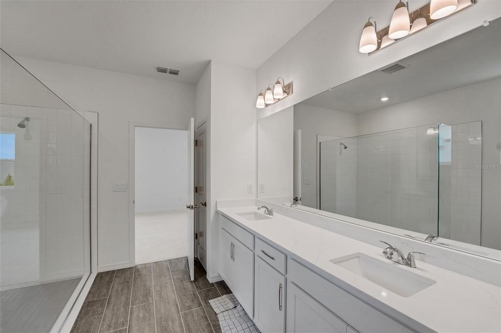 35163 Tuscan Hill Road Dade City, FL 33525 - Photo 34 of 45 a spacious bathroom with a double vanity sink a mirror and a shower