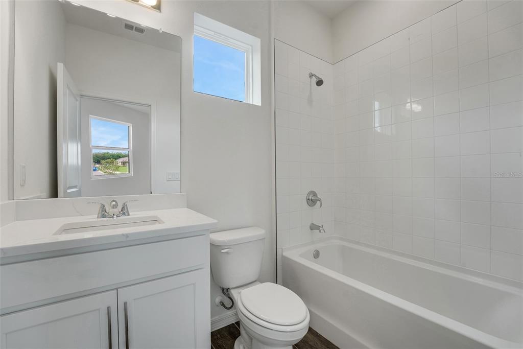 35163 Tuscan Hill Road Dade City, FL 33525 - Photo 39 of 45 a bathroom with a toilet a sink a mirror a bathtub and shower