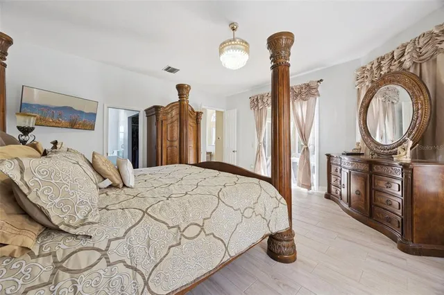 a bedroom with a bed a mirror and dresser