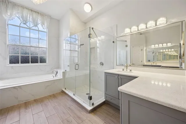 a spacious bathroom with a tub sink shower and mirror