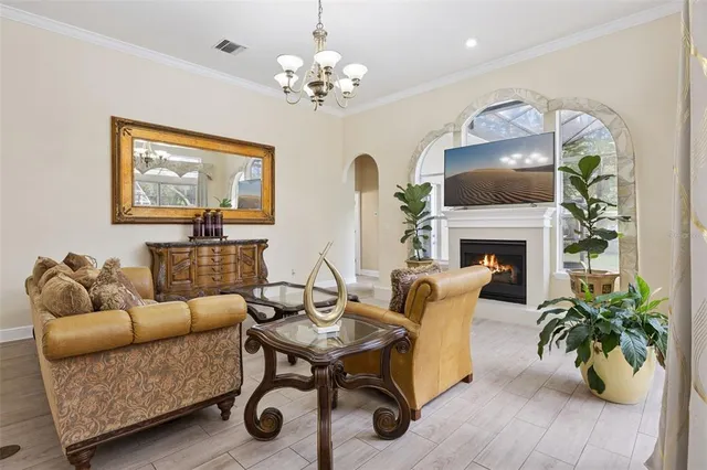 a living room with furniture a fireplace and a chandelier