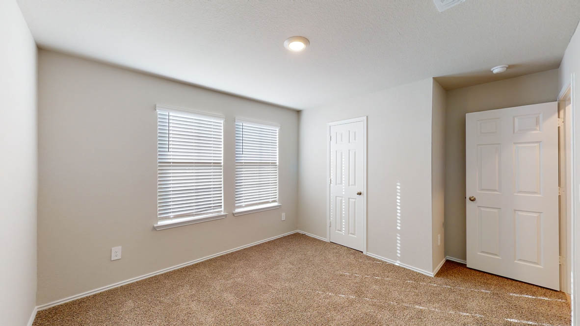 575 Hector Loop Georgetown, TX 78626 - Photo 20 of 28 Carpeted room featuring two windows with horizontal blinds, neutral wall paint, white baseboards, and two paneled interior doors