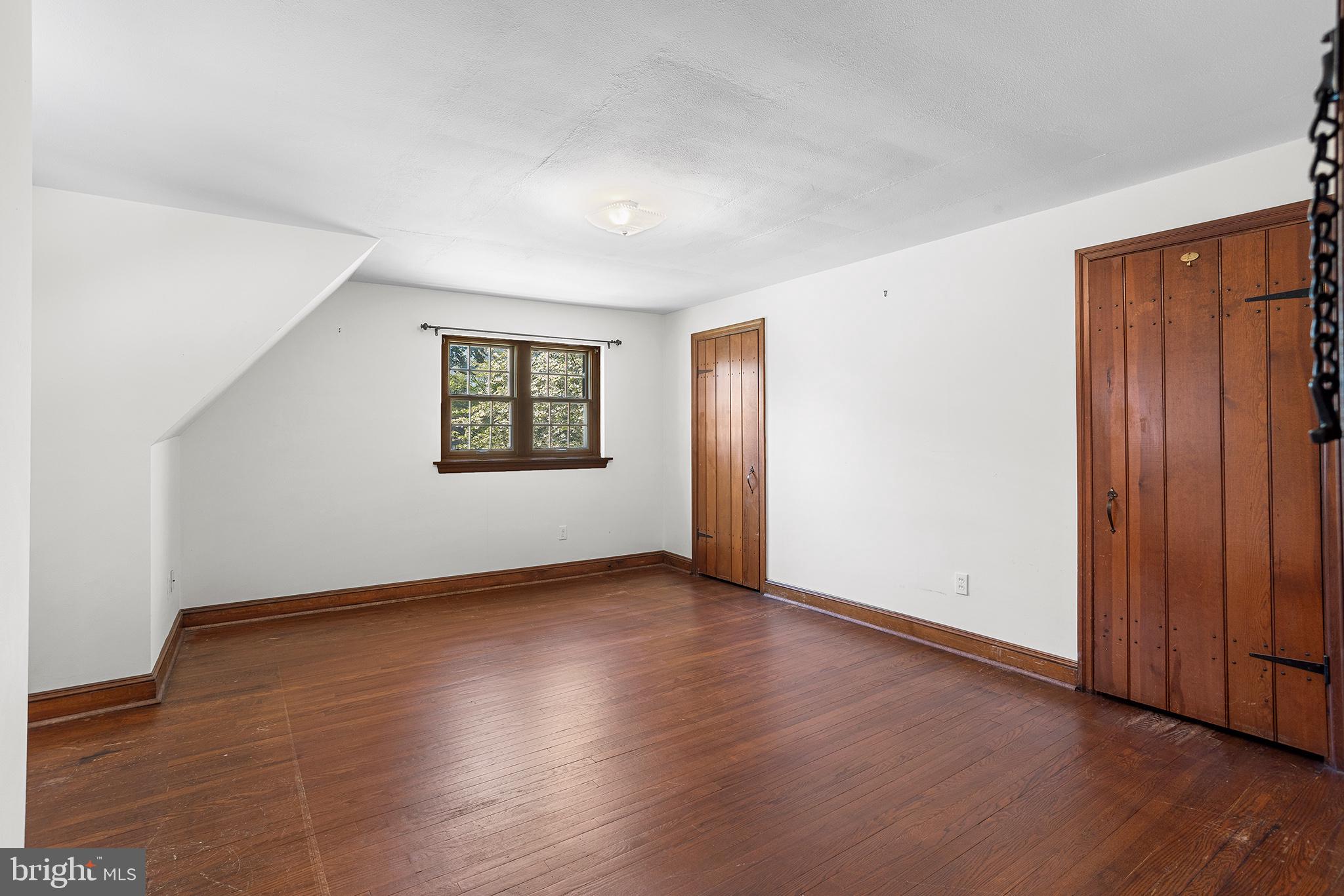 217 East Thomson Avenue Springfield, PA 19064 - Photo 19 of 32 an empty room with wooden floor and windows