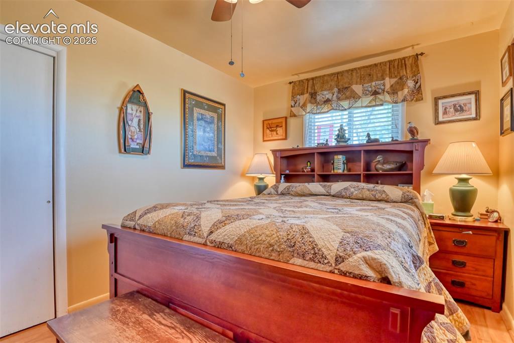 22558 Enoch Road Calhan, CO 80808 - Photo 34 of 50 a bedroom with a bed and wooden floor