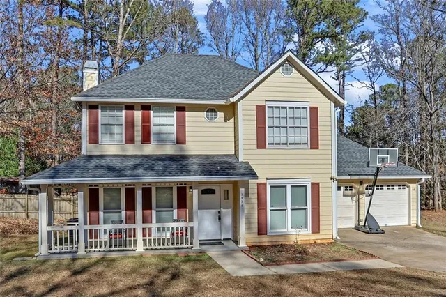 a view of a house with a yard and potted plants