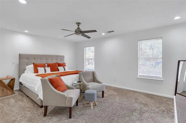 a bedroom with a bed a couch and window