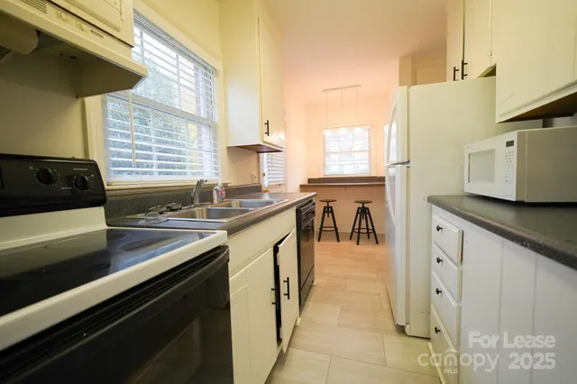 a kitchen with stainless steel appliances a sink a stove and a window