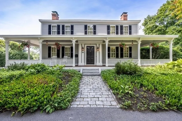 an aerial view of a city with lots of residential buildings ocean and mountain view in back