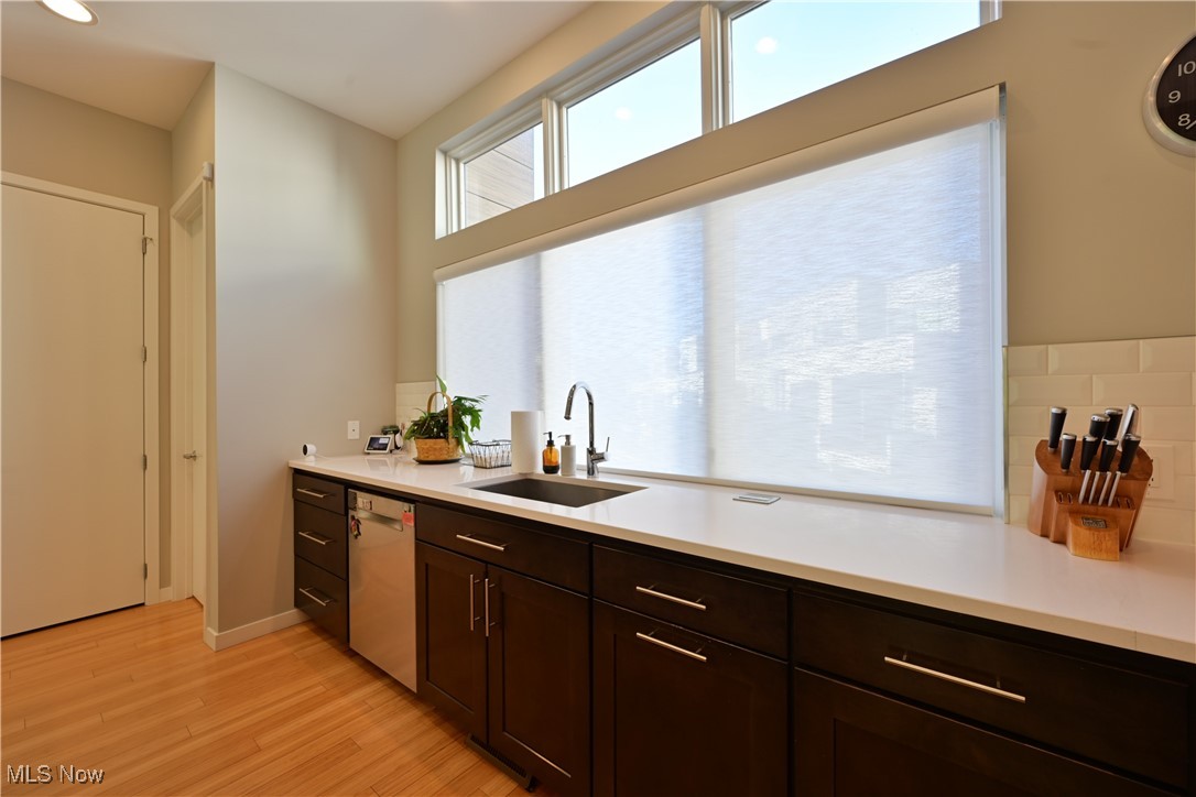 18875 Riversouth Fairview Park, Unit 30 Cleveland, OH 44126 - Photo 8 of 39 Kitchen with dark brown cabinets, light wood finished floors, dishwasher, light stone countertops, and recessed lighting