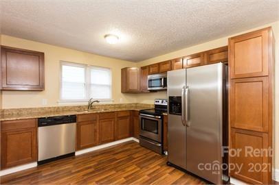 1714 Club Road, Unit 6 Charlotte, NC 28205 - Photo 3 of 14 a kitchen with granite countertop stainless steel appliances and wooden cabinets