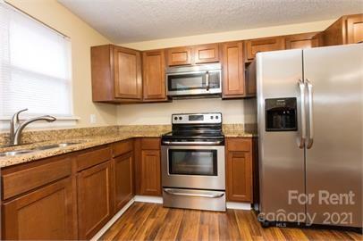 1714 Club Road, Unit 6 Charlotte, NC 28205 - Photo 5 of 14 a kitchen with stainless steel appliances granite countertop a refrigerator microwave and sink