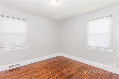 1714 Club Road, Unit 6 Charlotte, NC 28205 - Photo 9 of 14 an empty room with wooden floor and windows