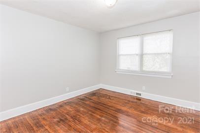 1714 Club Road, Unit 6 Charlotte, NC 28205 - Photo 10 of 14 an empty room with wooden floor and windows