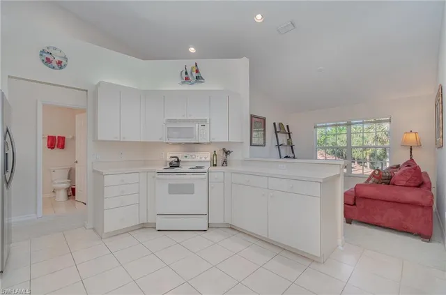 a kitchen with white cabinets and white appliances