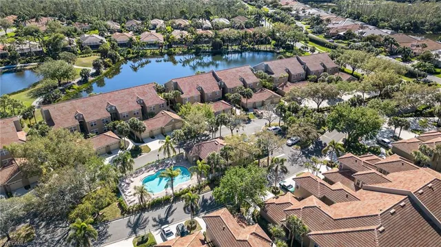 an aerial view of a house with a yard and lake view in back