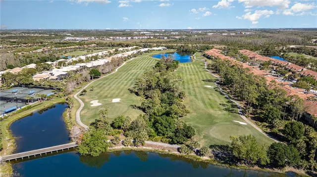 an aerial view of ocean and residential houses with outdoor space