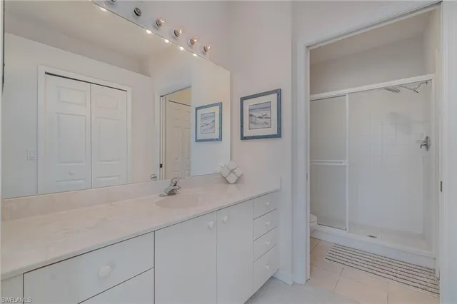 a bathroom with a shower sink vanity and mirror