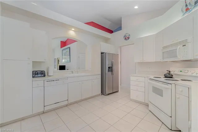 a kitchen with white cabinets and sink