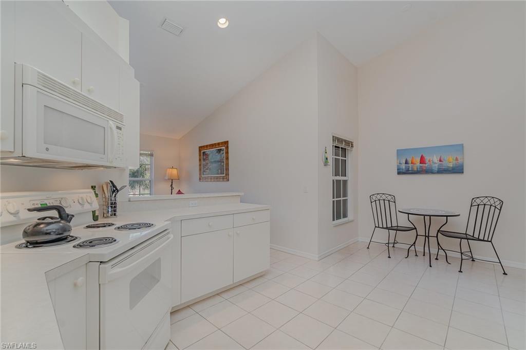 20151 Seagrove Street, Unit 207 Estero, FL 33928 - Photo 10 of 22 a kitchen with cabinets and chairs