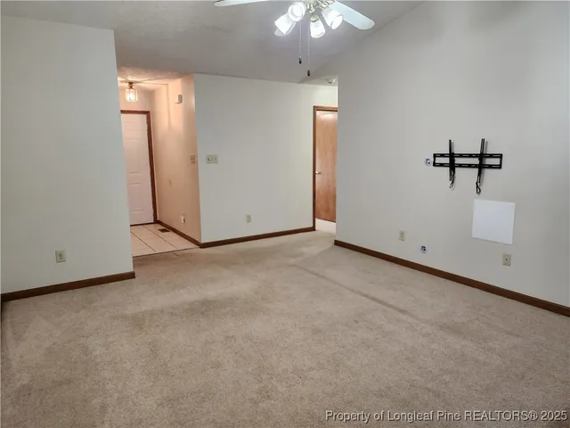 en empty room with windows and fan