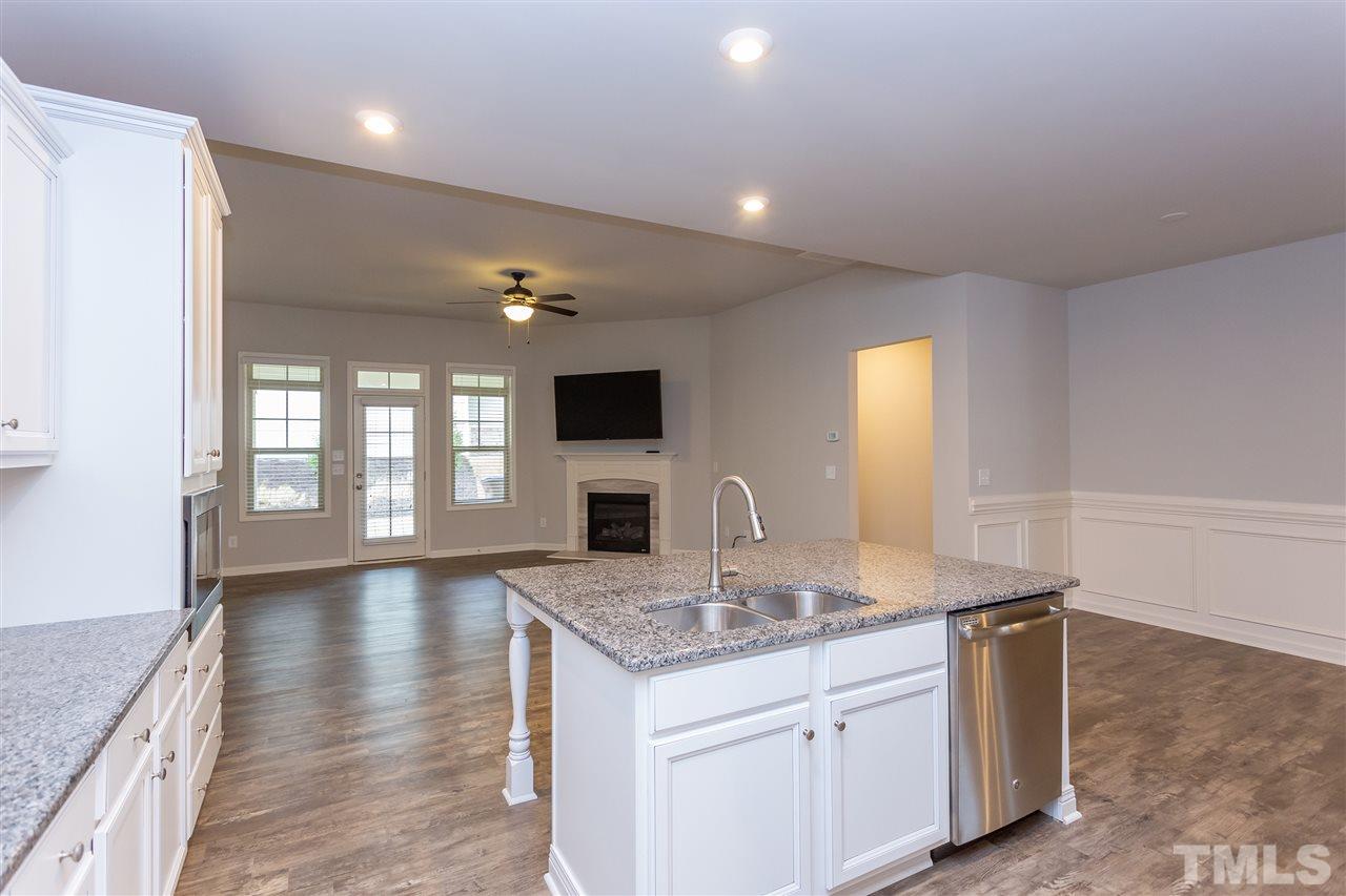 400 Piazza Way Wake Forest, NC 27587 - Photo 3 of 25 a kitchen with granite countertop a sink cabinets and wooden floor