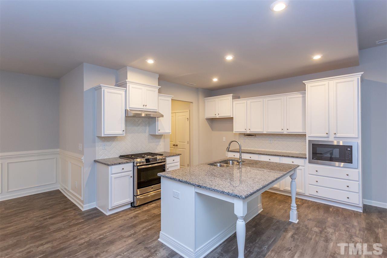 400 Piazza Way Wake Forest, NC 27587 - Photo 5 of 25 a kitchen with a stove a sink and a refrigerator