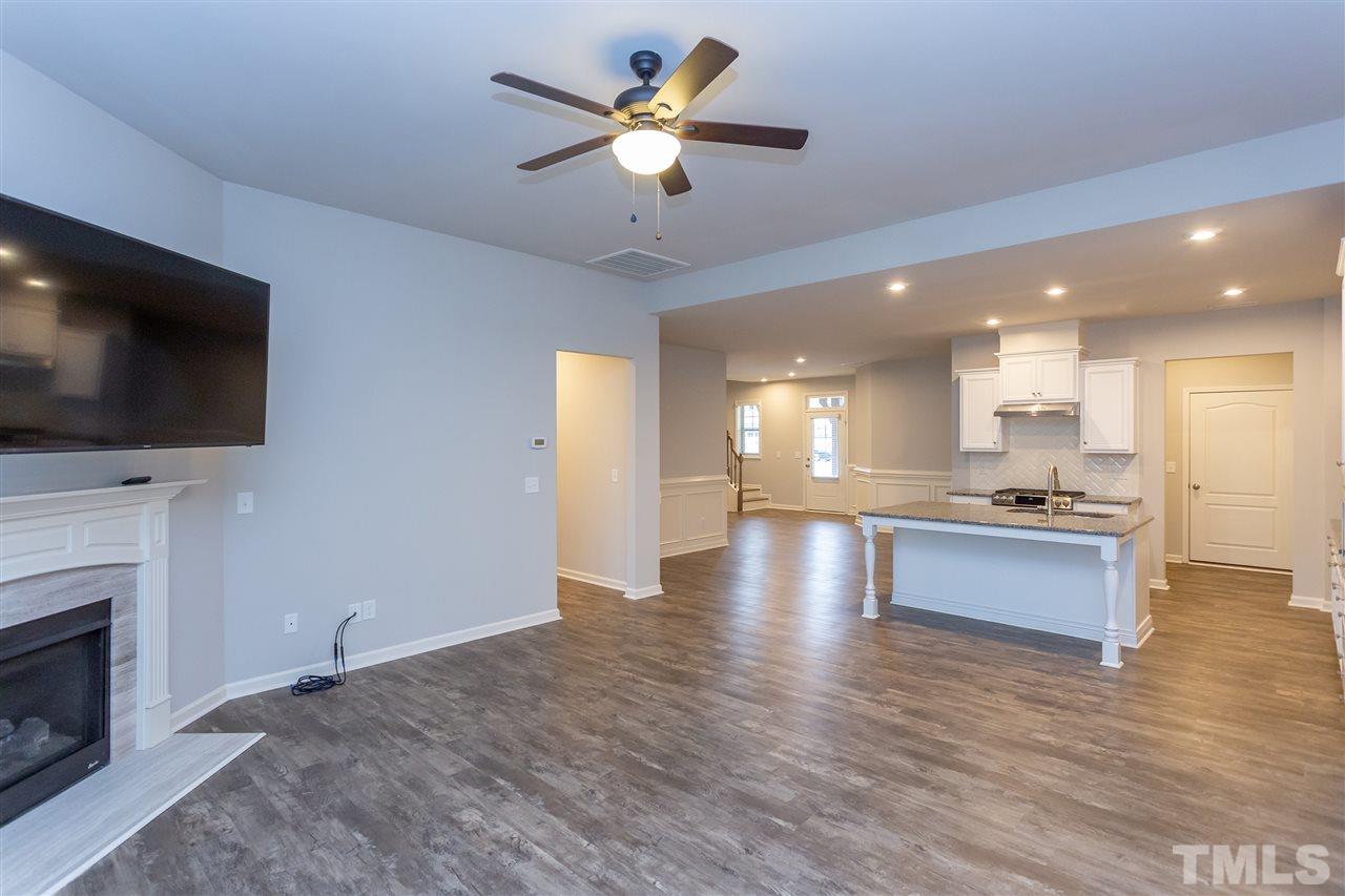 400 Piazza Way Wake Forest, NC 27587 - Photo 6 of 25 a view of an empty room and kitchen with fireplace wooden floor